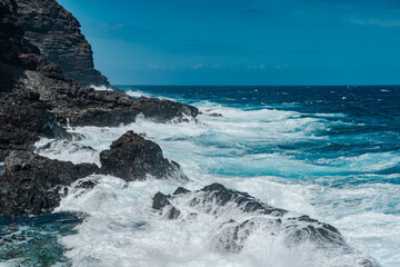 Makapuʻu Tide Pools, basalt comes from the Koʻolau volcano in eastern Oahu, Hawaii Geology. Waves hitting the rocks. 
