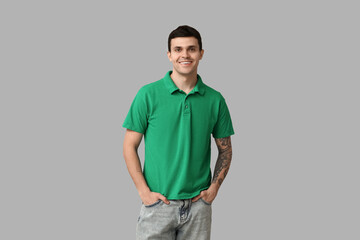 Fototapeta premium Handsome young man in stylish green t-shirt on grey background