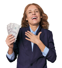 Mid-aged Caucasian with dollars in studio laughs out loudly keeping hand on chest.