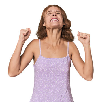 Redhead mid-aged Caucasian woman in studio celebrating a victory, passion and enthusiasm, happy expression.