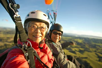 Tuinposter Active senior couple paragliding © VaCity