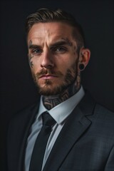 Tattooed businessman in a suit with colorful tattoos on his hands, neck, head and face, symbolizing an unconventional lifestyle.