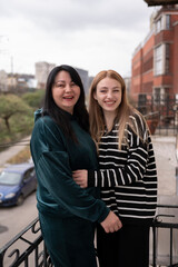 Two women standing on the balcony	
