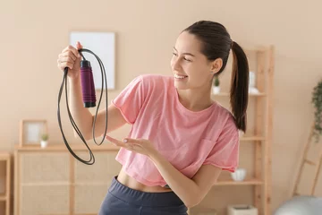 Badkamer foto achterwand Sporty female blogger with skipping rope at home © Pixel-Shot