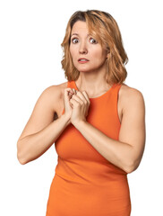 Blonde middle-aged Caucasian woman in studio scared and afraid.