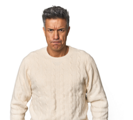 Middle-aged Latino man blows cheeks, has tired expression. Facial expression concept.