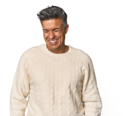 Middle-aged Latino man laughs and closes eyes, feels relaxed and happy.