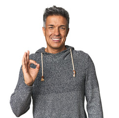 Middle-aged Latino man cheerful and confident showing ok gesture.