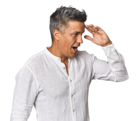 Middle-aged Latino man looking far away keeping hand on forehead.