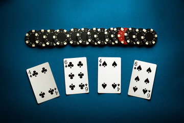 Chips and playing cards with a winning combination of two pairs on a blue table. Concept of luck or winning in poker club