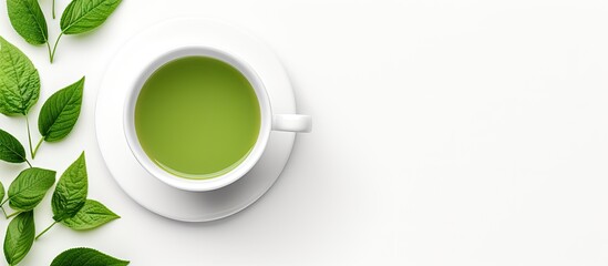 A refreshing cup of green tea served in a delicate teacup, with vibrant green leaves displayed on a saucer against a clean white background - obrazy, fototapety, plakaty