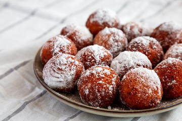 Homemade Fried Donut Holes with Powdered Sugar on a Plate, low angle view.