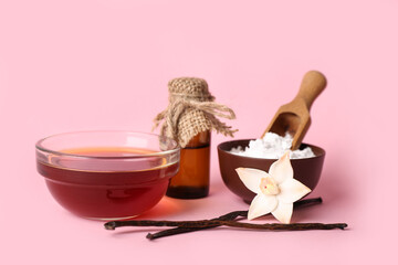 Bowls with vanilla extract, powder and sticks on pink background