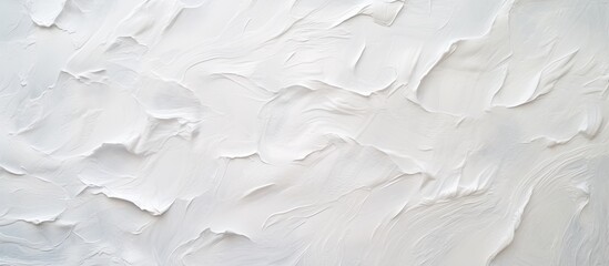 A closeup of a liquid white paint texture on a wall, resembling a snowy landscape with freezing patterns. The monochrome photography captures the plasters smooth surface