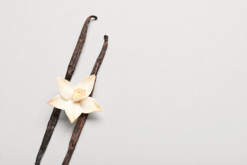 Aromatic vanilla sticks with flower on light background