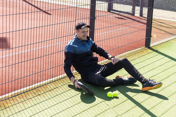 paddle player resting against the wall entertained by the ball