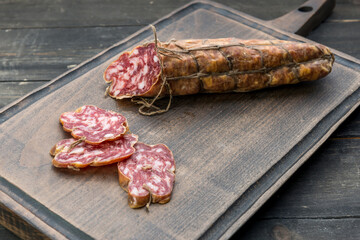 sausage with sliced pieces sliced on a wooden board