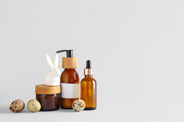 Set of cosmetic products, Easter eggs and ceramic bunny on light background