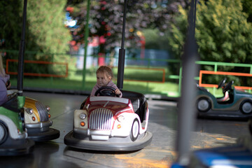 The Joyous Ride, A Whimsical Encounter of a Little Boy Cruising a Bumper Car at the Vibrant Park