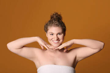 Obraz premium Happy young woman with makeup foundation on her face against brown background