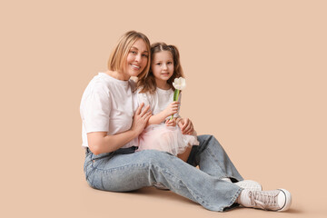 Little girl greeting her mom with Mother's Day on beige background