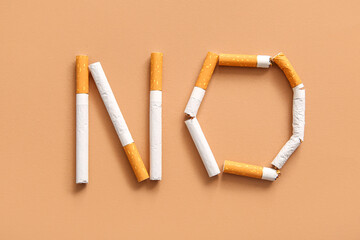 Word NO made of cigarettes on brown background, closeup. Stop smoking concept.