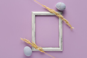 Beautiful composition with frame, Easter eggs and ears of wheat on color background