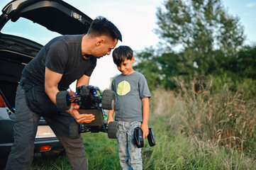 Middle aged father showing to his young son how their new toy car works