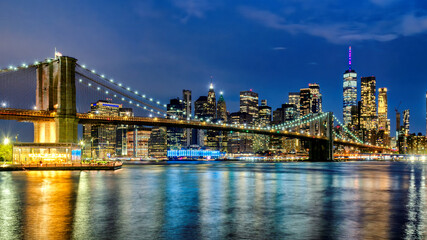 Manhattan skyline and Brooklyn Bridge illuminated at night in New York City