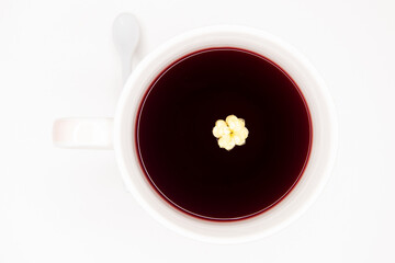 Xícara de chá de Hibisco, vermelho com flor amarela no chá. Tons de vermelho, branco e amarelo,...