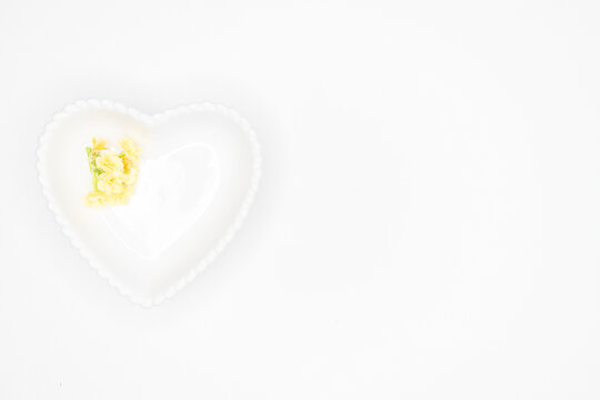 Pequeno pire branco em formato de coração com pequenas bolinhas nas bordas. Fundo branco alta resolução, flores amarelas, dia das mães, namorados, amor, carinho