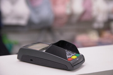 A photo showing a detailed view of the acquiring payment terminal lying on the table, emphasizing...