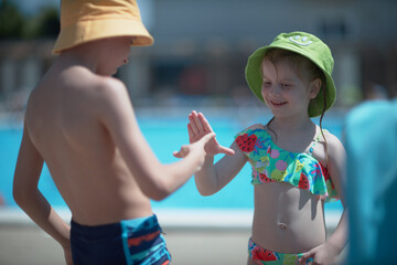 Boy and Girl Standing in Front of Pool