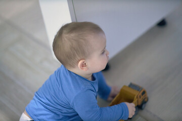 Baby Sitting on Floor Playing With Toy Truck