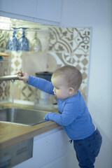 Little Boy Standing in Front of Kitchen Sink