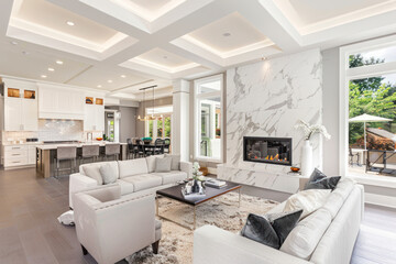 Contemporary living room with open concept view through to dining room kitchen and a marble fireplace with gas fire.