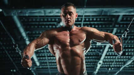 A dedicated and well-built man is performing a cable chest fly exercise at a state-of-the-art gym, focusing on muscle growth and chest development. Camera 8K RAW. 