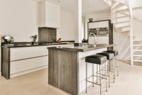 Modern kitchen interior with island and staircase