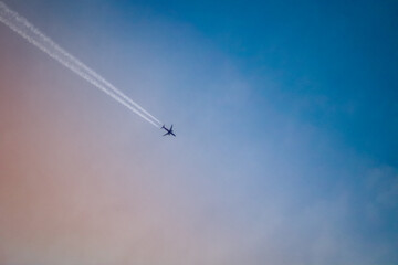 Flugzeug fliegt im orange blauen morgen Himmel