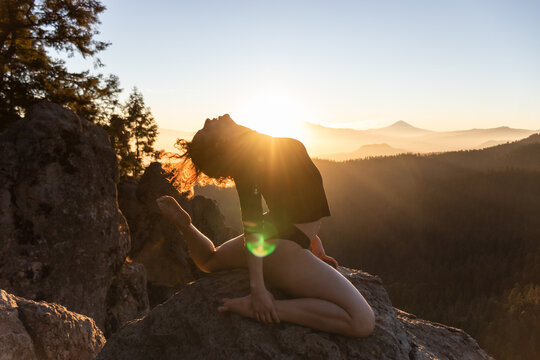 Silhouetted dancer at sunset on a mountain peak