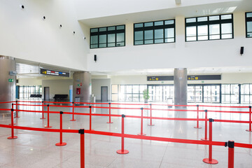 Airport departure and arrivals interior of baggage check in building with no people in the queue