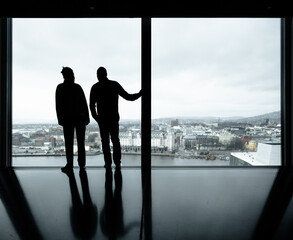 silhouettes of people in front of a glass facade - 770095766