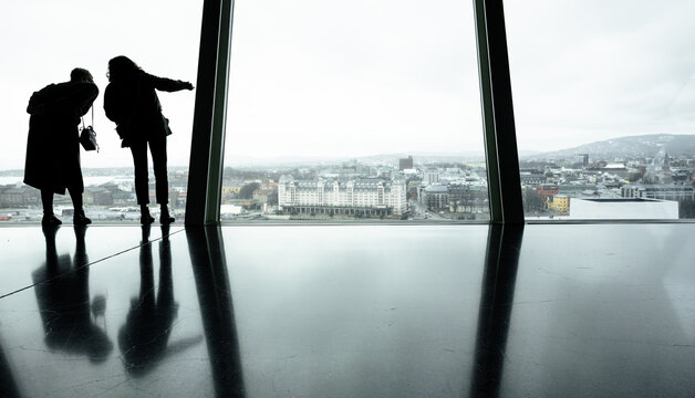 silhouettes of people in front of a glass facade