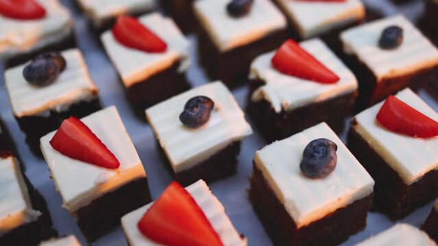 Beautiful multicolored decorated baked sweet tasty candy bar dessert selection with cake, pie and pastries catering banquet table on a kids children party, coffee break buffet at a conference