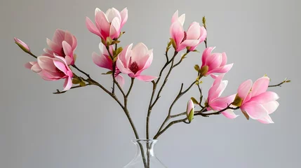 Gordijnen Bouquet of sprigs of blooming pink artificial magnolia in clear glass vase © Ziyan
