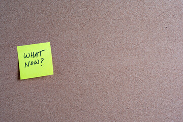 Sticky Note with What Now on a Corkboard