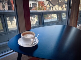 enjoying a cup of latte on a saucer by the window