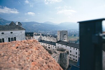 Scenic view of historic buildings against mountains with a blurred foreground, under a clear sky.