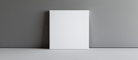 Blank white square canvas placed against a neutral gray backdrop, resembling a mock-up poster or template.