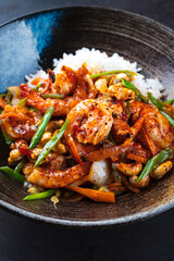 Traditional Thai fried king prawns with vegetable, cashew nuts and rice served as close-up in a design plate